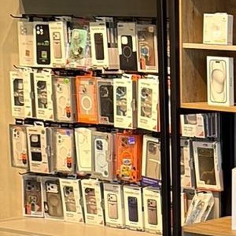 Parede com várias capinhas de celular em embalagens penduradas