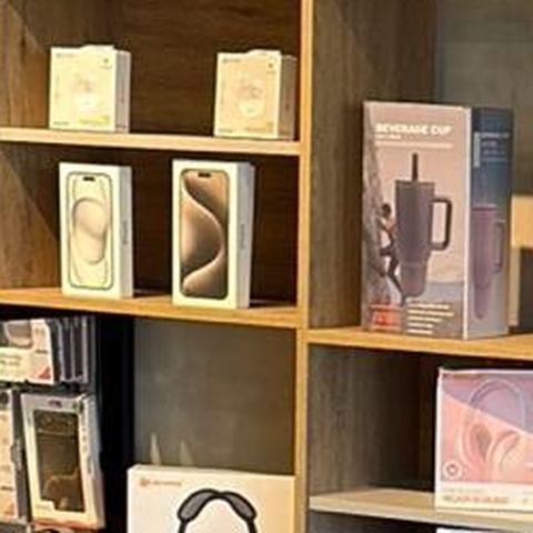 Caixas de iPhone expostas em prateleira de madeira na loja